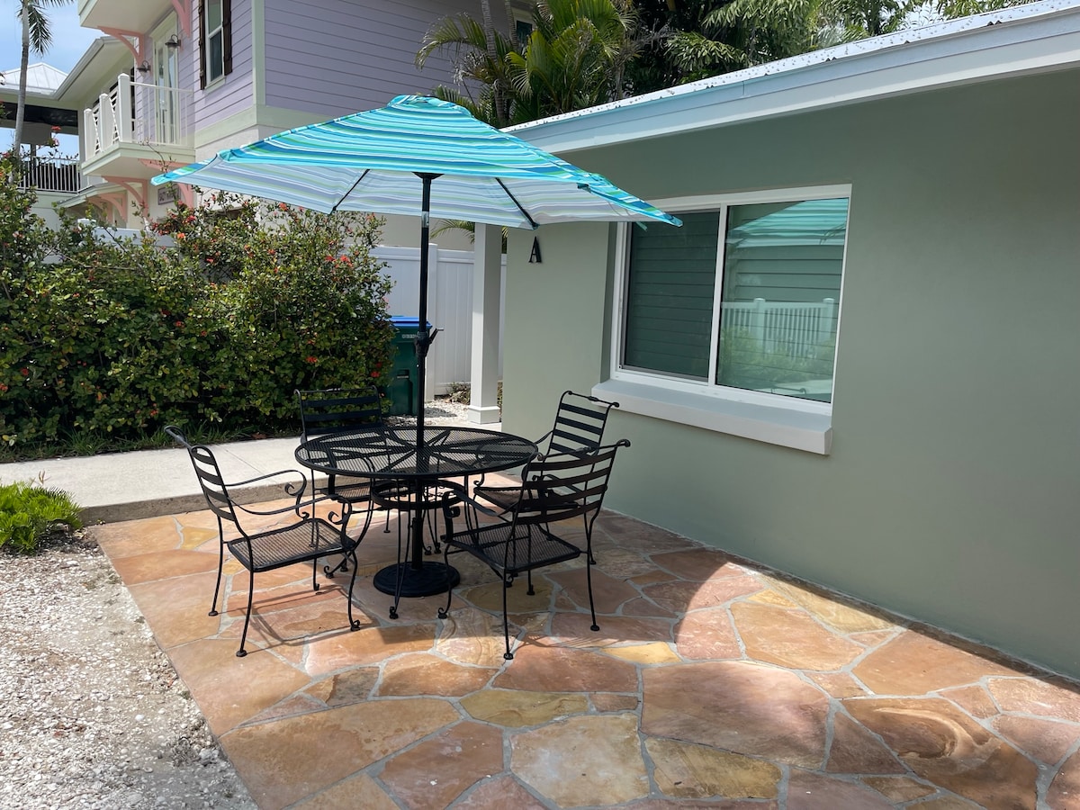 Private outdoor patio with table and turquoise umbrella at Palm Haven