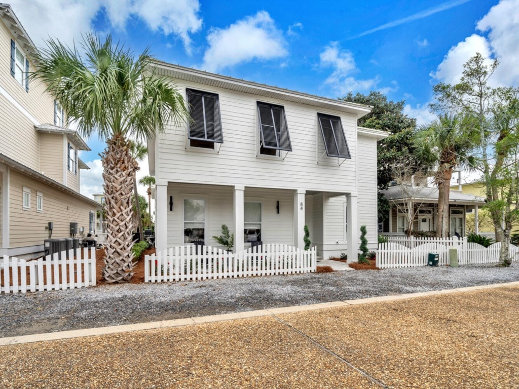 Exterior of Sea-N-Double with palm trees and white picket fence