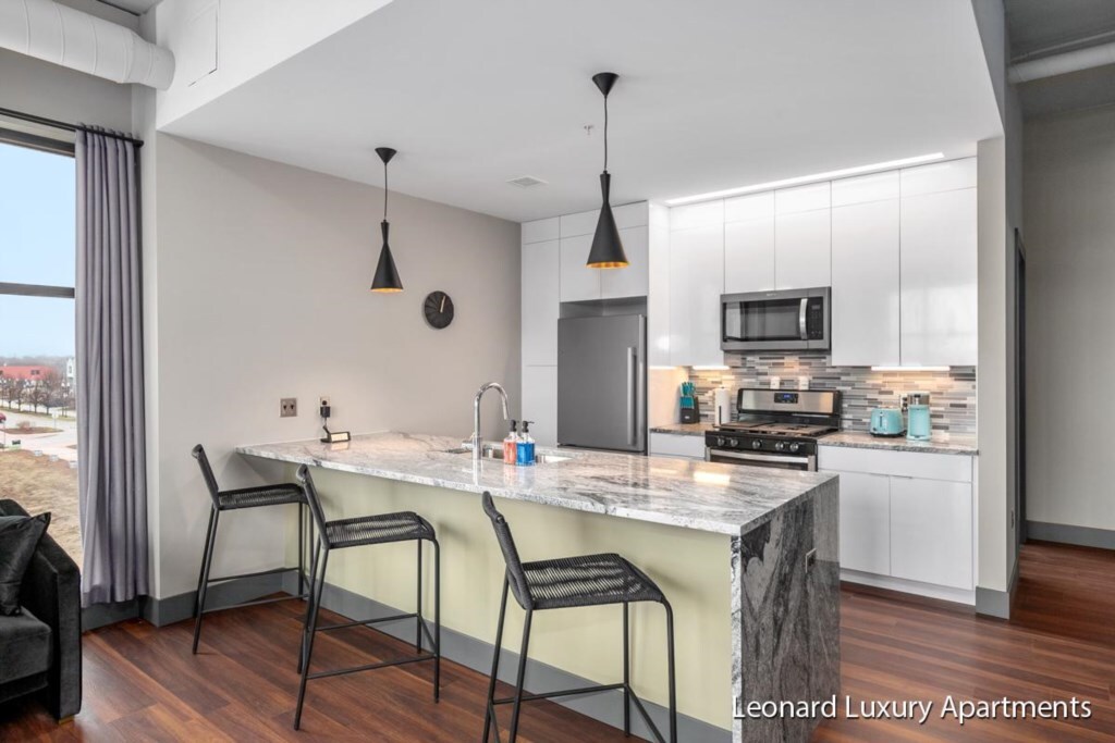 White kitchen with island at Downtown Muskegon Apartment #306