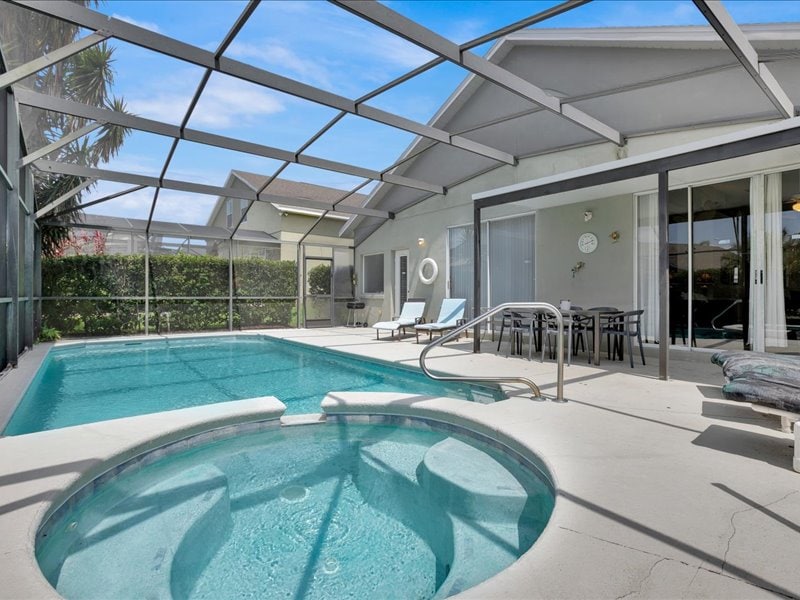 Private spa in the foreground with the screened pool and villa patio beyond