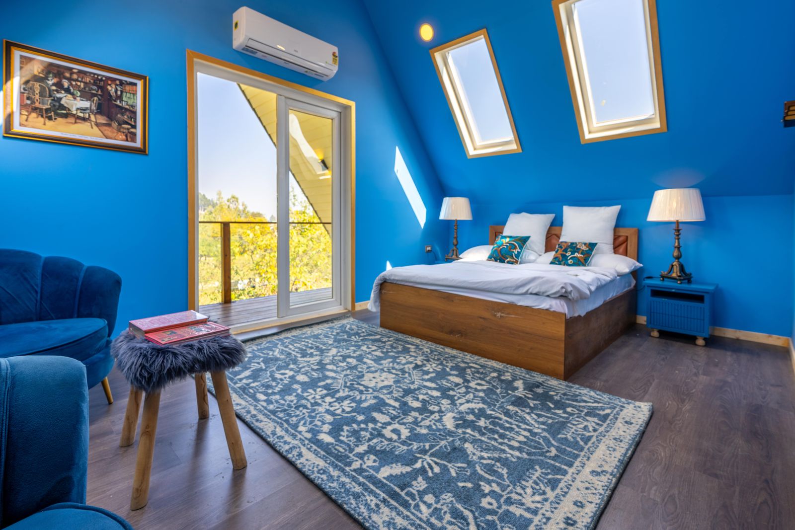 Bright blue attic bedroom with skylights and warm wood