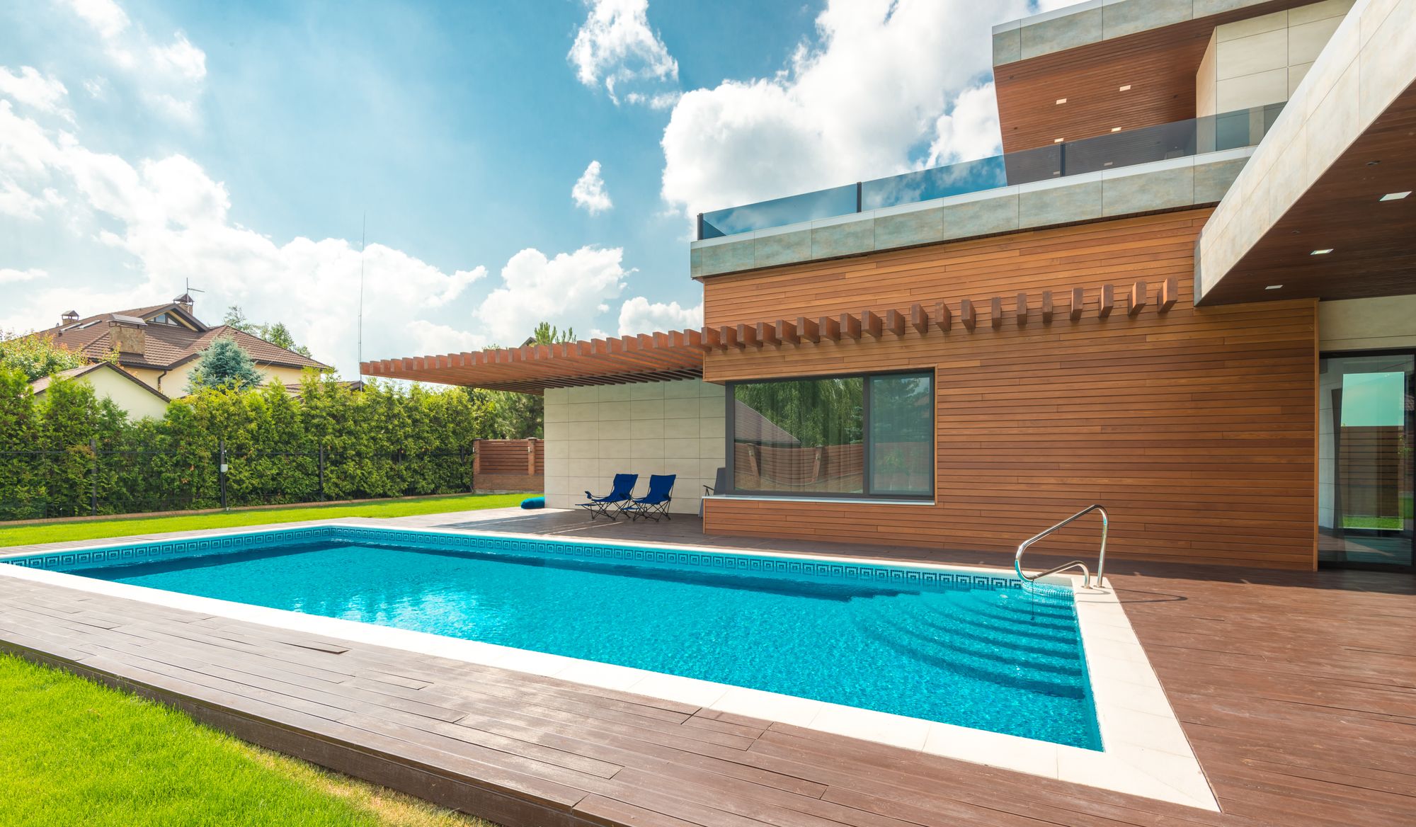 Sunny vacation home with a turquoise backyard pool and lawn