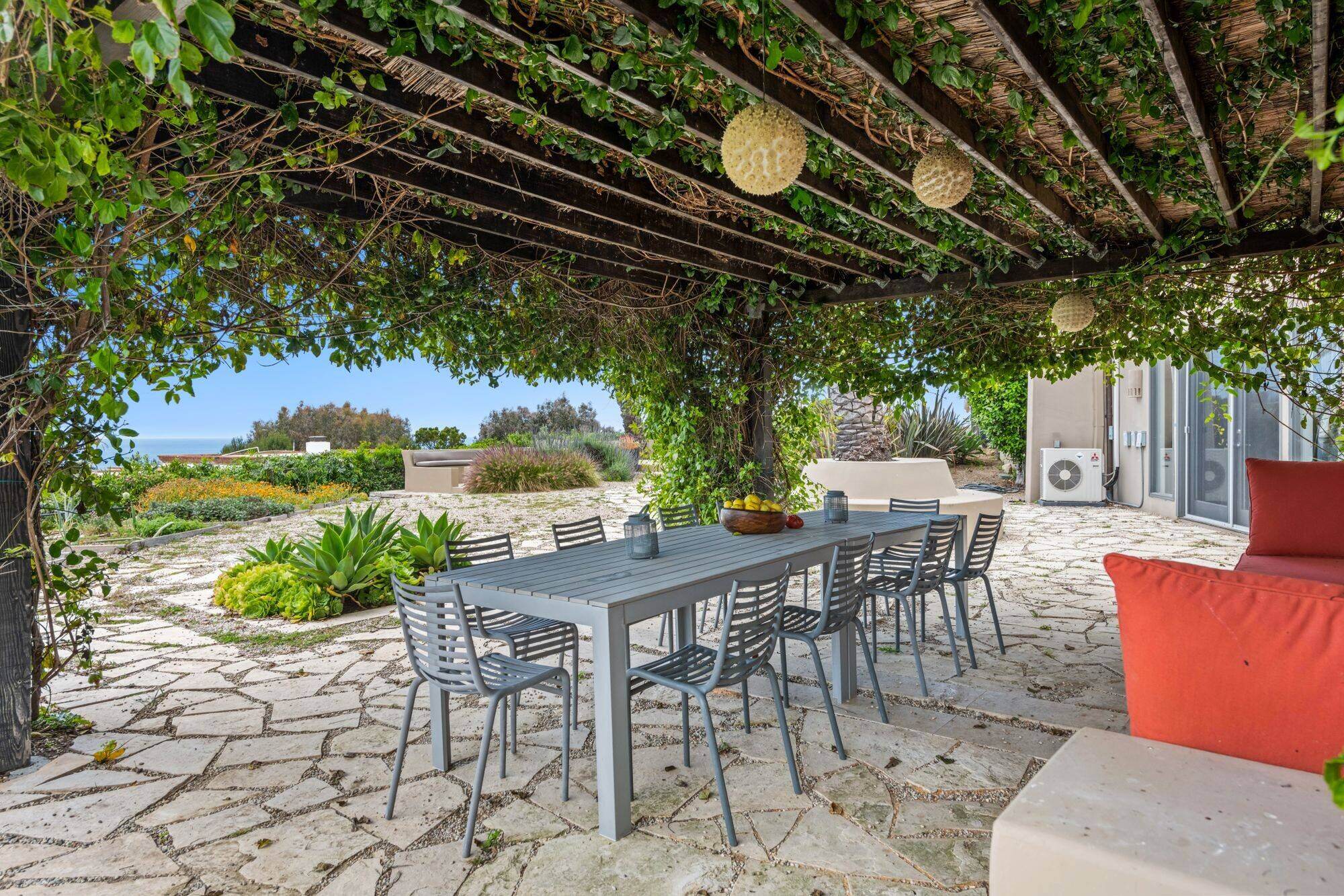 Sunny garden dining patio beneath a vine-covered pergola