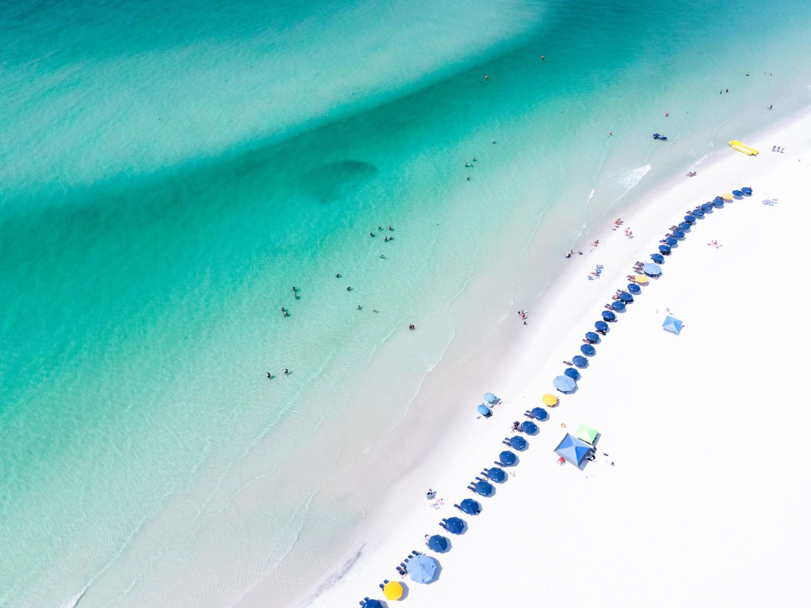 Turquoise Gulf water and colourful umbrellas along a Florida Panhandle beach